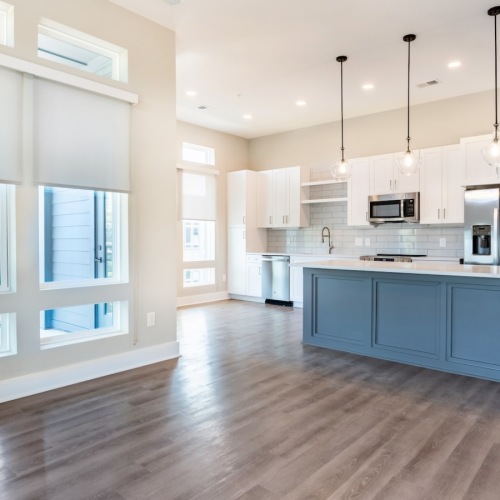 living room with wood flooring and view of the kitchen