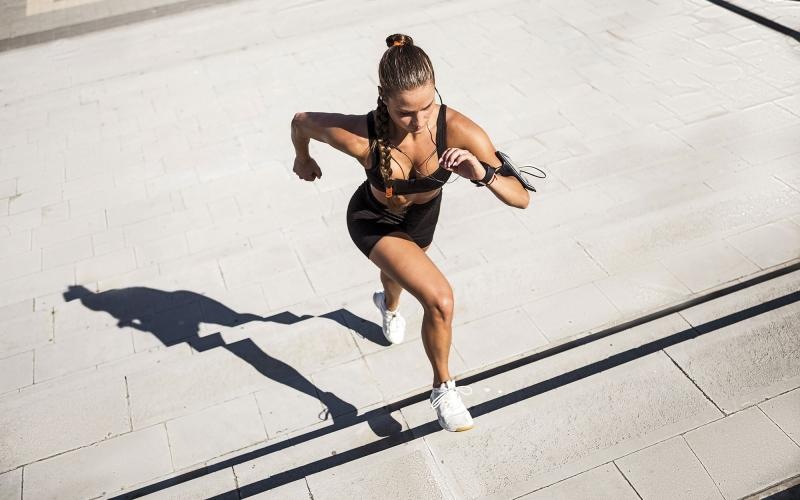woman exercises running outside up stairs